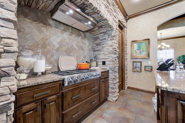 2293 Cottage Ln, Blanchard, OK 73010 - kitchen with stainless steel gas stovetop, ornamental molding, a chandelier, custom exhaust hood, and light stone countertops
