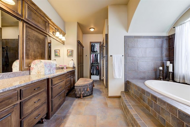2293 Cottage Ln, Blanchard, OK 73010 - full bathroom with a bath, vanity, stone finish flooring, a tile shower, and a walk in closet