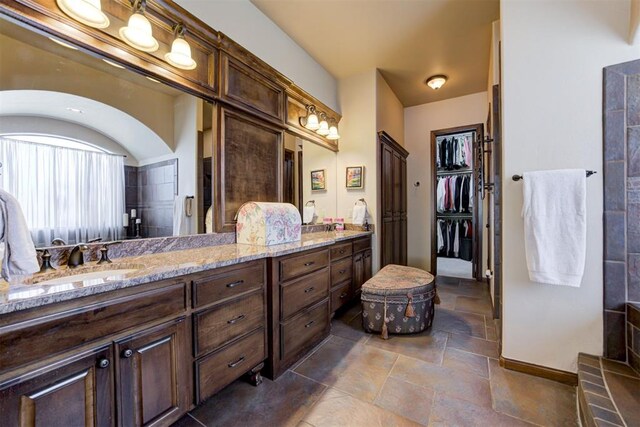 2293 Cottage Ln, Blanchard, OK 73010 - full bathroom with double vanity, stone tile flooring, and a spacious closet