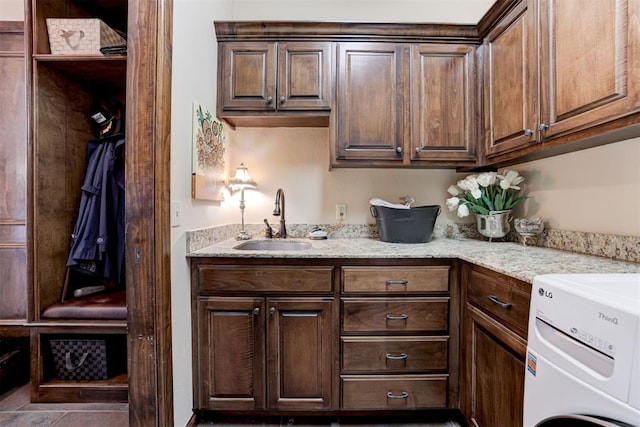 2293 Cottage Ln, Blanchard, OK 73010 - kitchen with light stone countertops, washer / clothes dryer, and dark brown cabinetry