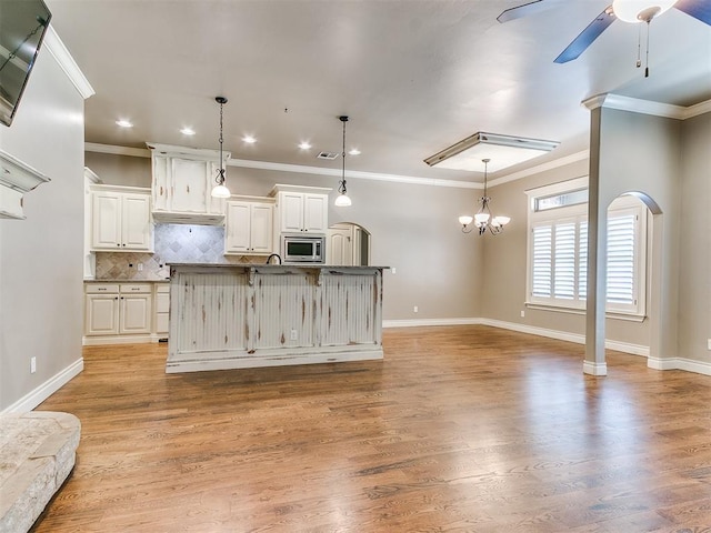 13340 Greenscape Rd, Piedmont, OK 73078 - kitchen with open floor plan, stainless steel microwave, recessed lighting, ceiling fan with notable chandelier, and backsplash