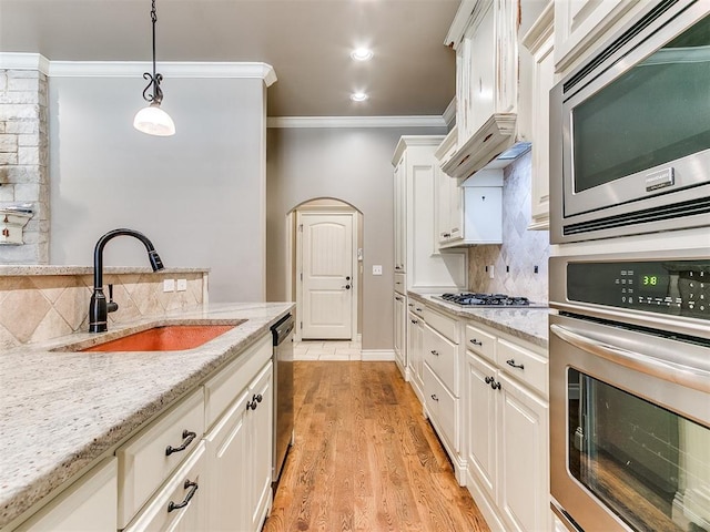 13340 Greenscape Rd, Piedmont, OK 73078 - kitchen with appliances with stainless steel finishes, ornamental molding, white cabinets, decorative backsplash, and a sink