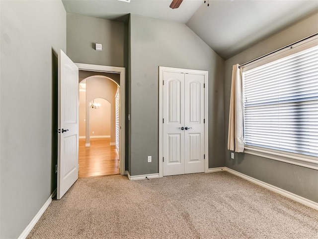 13340 Greenscape Rd, Piedmont, OK 73078 - unfurnished bedroom featuring arched walkways, a closet, light carpet, lofted ceiling, and baseboards