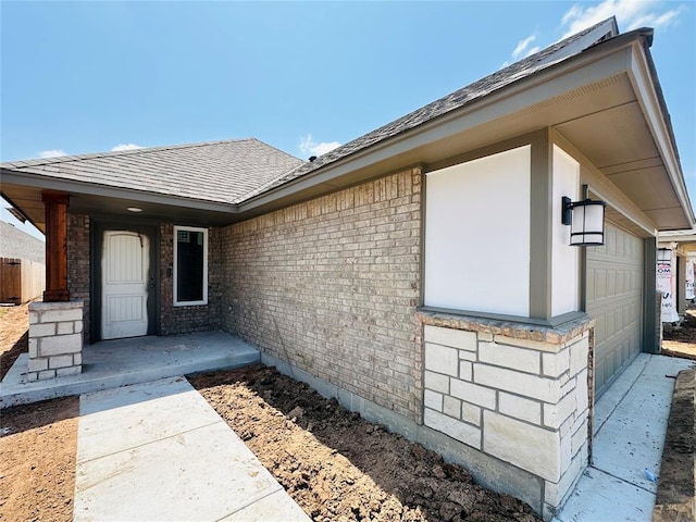 1104 SW 139th St, Oklahoma City, OK 73170 - view of exterior entry featuring a garage, brick siding, and a shingled roof