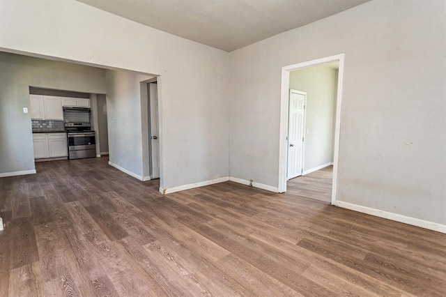 empty room with dark wood-type flooring and baseboards