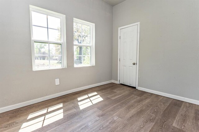 unfurnished room featuring baseboards and wood finished floors