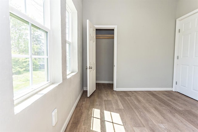 unfurnished bedroom featuring a closet, baseboards, and wood finished floors