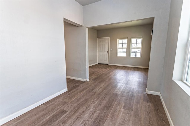 empty room featuring dark wood-style floors and baseboards