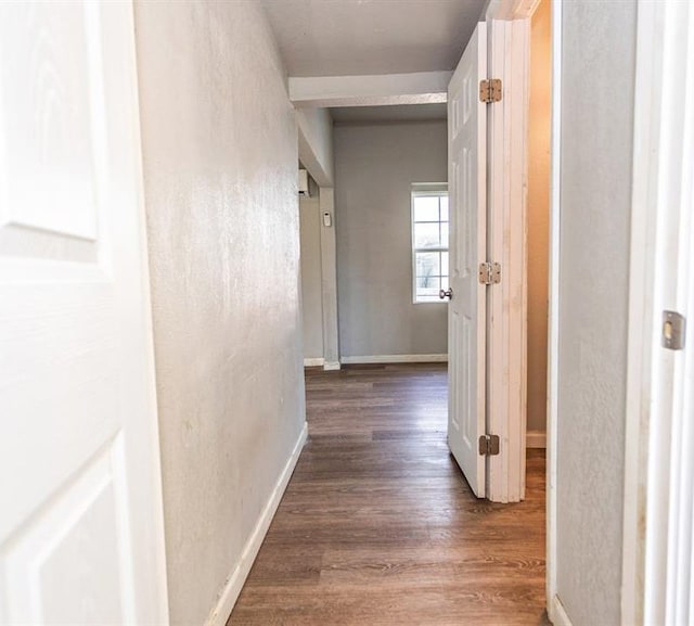 corridor with baseboards and wood finished floors