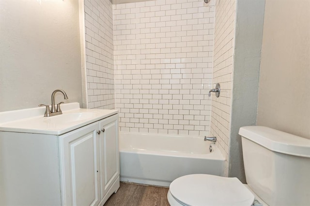 bathroom with toilet, bathtub / shower combination, wood finished floors, and vanity