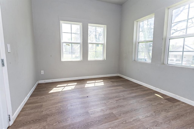 spare room featuring wood finished floors and baseboards
