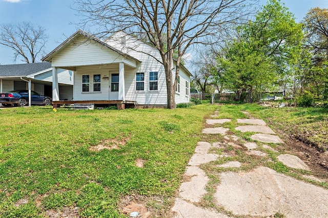 exterior space featuring a yard, fence, and an attached carport