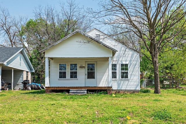 view of front of property with a porch, a front yard, and fence