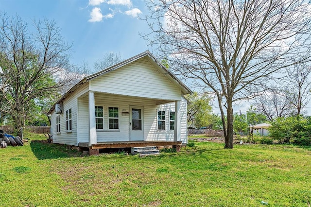 view of front of house featuring a front yard, a porch, and fence