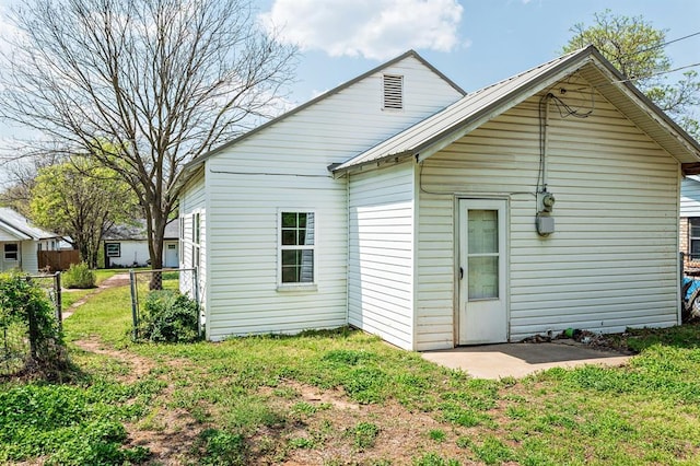 back of property featuring metal roof and fence