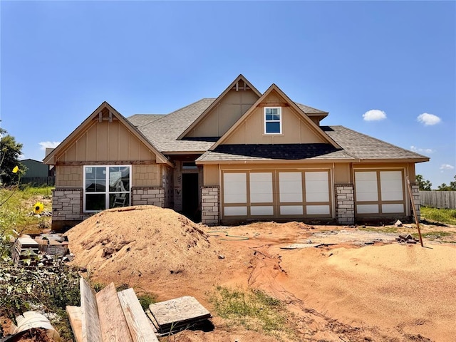 10156 NW 100th St, Yukon, OK 73099 - view of front of home with a shingled roof, stone siding, and board and batten siding