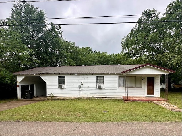 ranch-style home featuring a porch, concrete driveway, a front yard, and metal roof