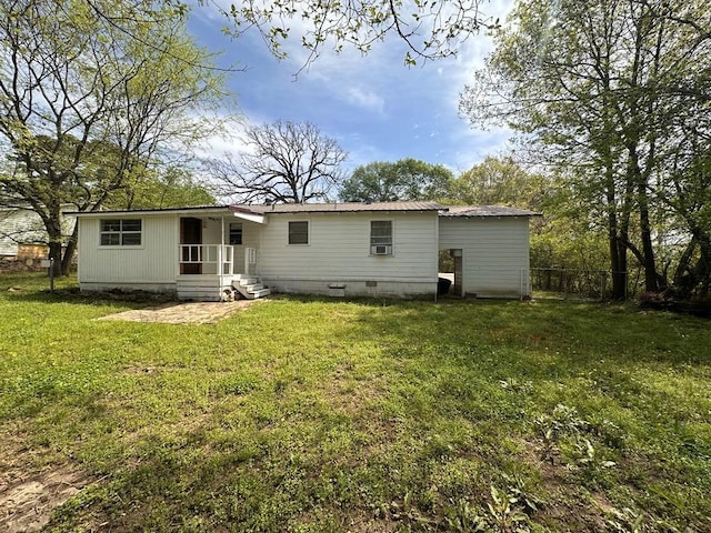 rear view of house with fence, a yard, crawl space, and metal roof