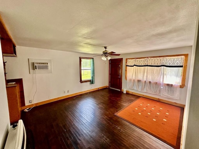interior space with wood-type flooring, baseboards, ceiling fan, a textured ceiling, and a baseboard heating unit