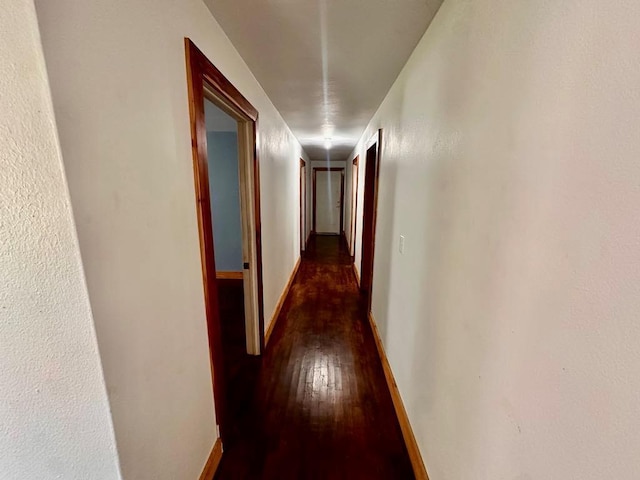 hall with wood-type flooring and baseboards
