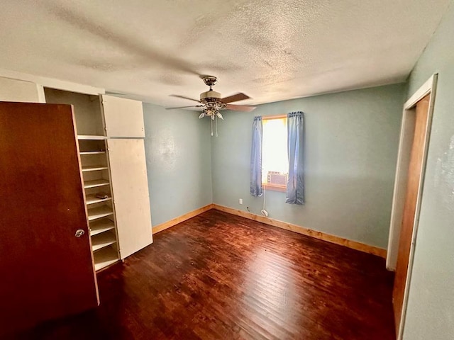 unfurnished bedroom featuring a textured ceiling, a ceiling fan, baseboards, wood finished floors, and a closet