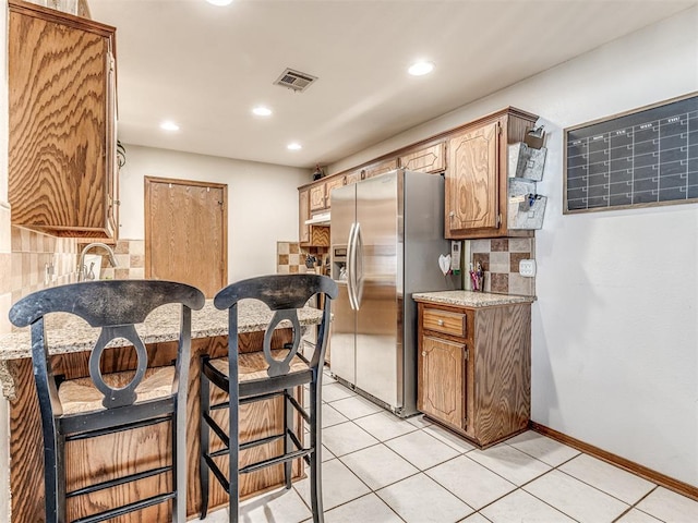 933 Luglena Ln, Purcell, OK 73080 - kitchen with stainless steel fridge, tasteful backsplash, recessed lighting, light countertops, and light tile patterned floors