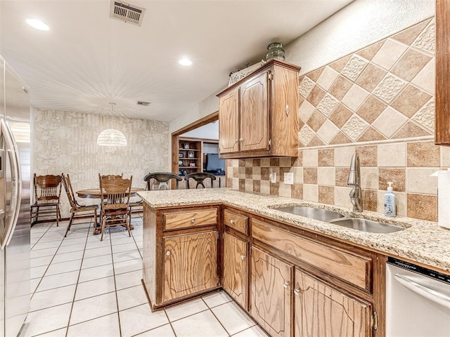 933 Luglena Ln, Purcell, OK 73080 - kitchen featuring stainless steel appliances, a sink, light stone counters, a peninsula, and recessed lighting
