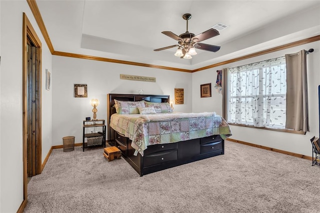 carpeted bedroom featuring a tray ceiling, crown molding, baseboards, and visible vents