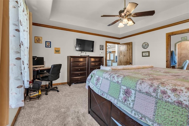 bedroom featuring a tray ceiling, light colored carpet, a ceiling fan, ornamental molding, and baseboards