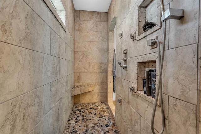 full bath featuring a walk in shower and stone finish flooring
