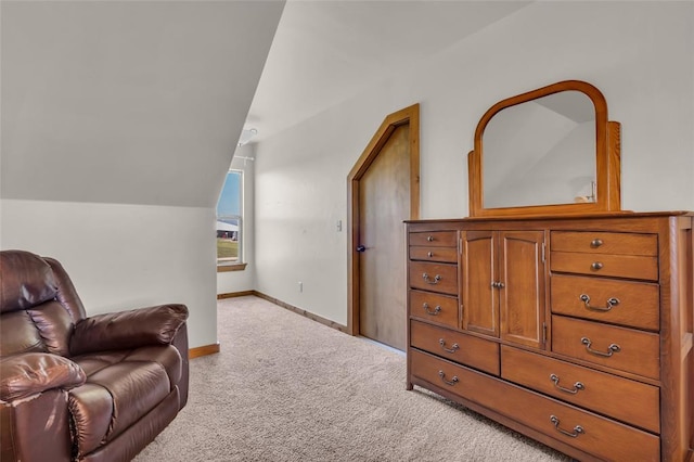 sitting room with baseboards, vaulted ceiling, and carpet floors