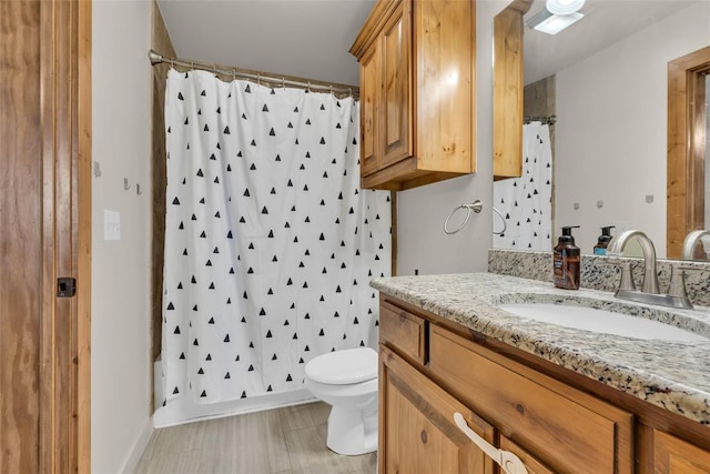 bathroom featuring toilet, vanity, and a shower with curtain