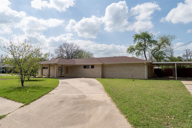 515 W Tennessee Ave, Pauls Valley, OK 73075 - view of front of house with concrete driveway, a front lawn, brick siding, and an attached carport