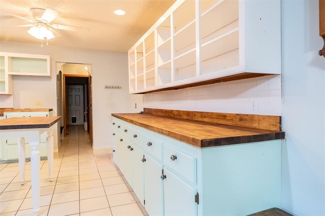 515 W Tennessee Ave, Pauls Valley, OK 73075 - kitchen featuring wood counters, a ceiling fan, light tile patterned floors, open shelves, and a textured ceiling