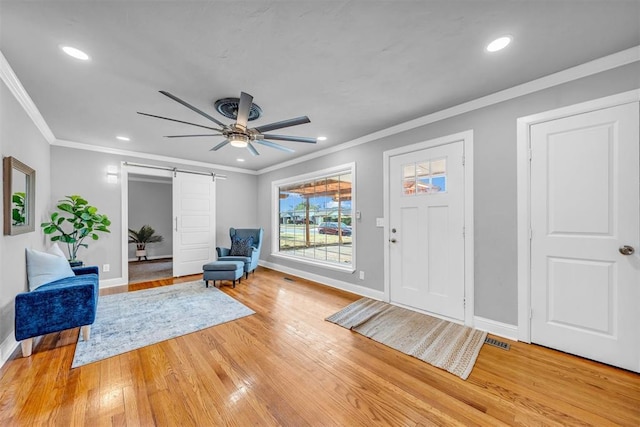 2736 Pembroke Ter, Oklahoma City, OK 73116 - foyer entrance featuring a barn door, a ceiling fan, light wood-style flooring, baseboards, and visible vents