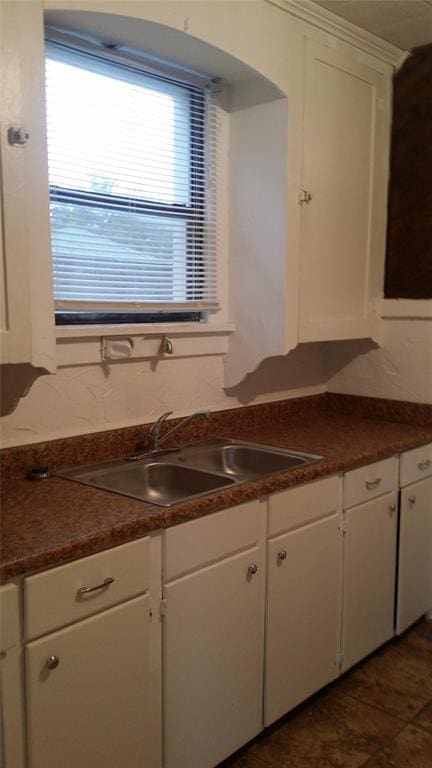 kitchen featuring white cabinetry and a sink