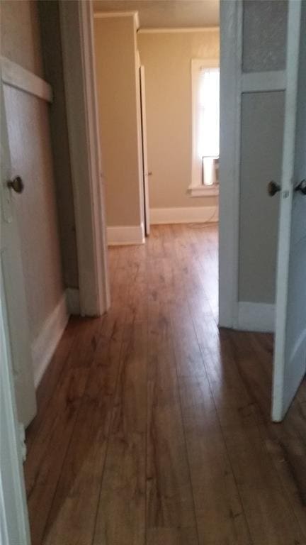 hallway with baseboards and wood finished floors