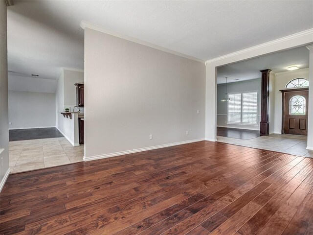 unfurnished living room featuring wood finished floors and ornamental molding