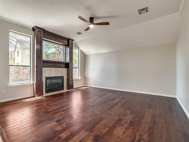 unfurnished living room featuring dark wood finished floors, a tiled fireplace, vaulted ceiling, visible vents, and ceiling fan