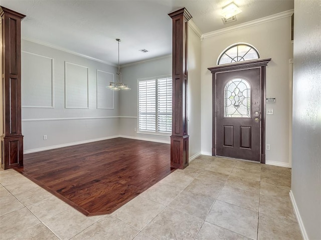 foyer entrance featuring crown molding, baseboards, light tile patterned flooring, and a healthy amount of sunlight