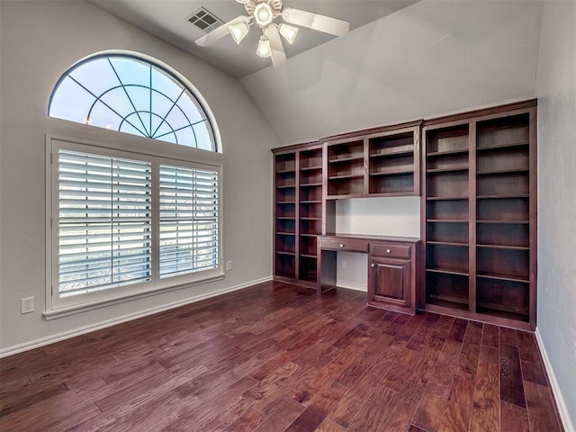 unfurnished office featuring dark wood-style floors, vaulted ceiling, visible vents, built in study area, and ceiling fan