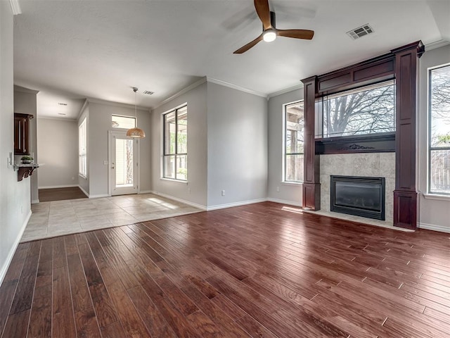 unfurnished living room featuring wood finished floors, visible vents, and baseboards
