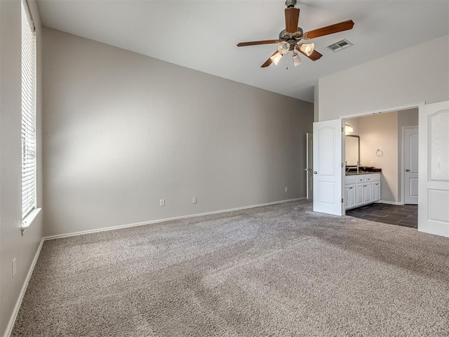 unfurnished bedroom with baseboards, visible vents, and dark carpet