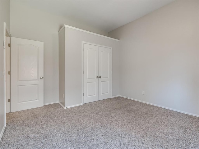 unfurnished bedroom featuring baseboards, carpet floors, and a closet