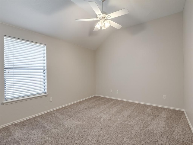 spare room featuring baseboards, lofted ceiling, a ceiling fan, and carpet