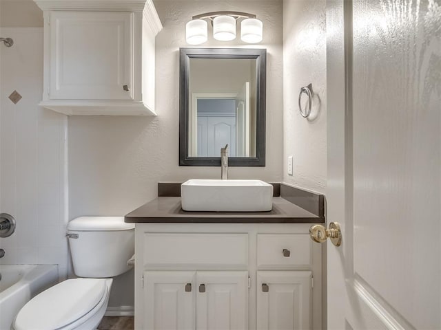full bath with toilet, a textured wall, vanity, and bathtub / shower combination