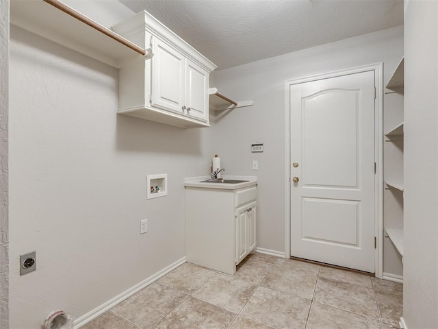 washroom with a sink, hookup for a washing machine, baseboards, electric dryer hookup, and cabinet space