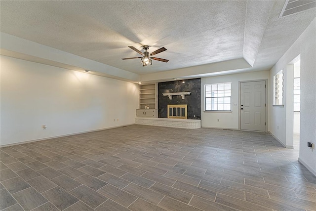 11800 Shasta Ln, Oklahoma City, OK 73162 - unfurnished living room featuring a textured ceiling, a ceiling fan, visible vents, baseboards, and built in shelves