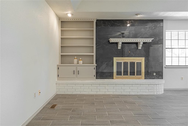 11800 Shasta Ln, Oklahoma City, OK 73162 - unfurnished living room with a large fireplace, built in features, baseboards, and wood tiled floor