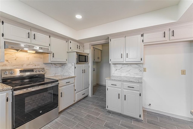 11800 Shasta Ln, Oklahoma City, OK 73162 - kitchen featuring baseboards, under cabinet range hood, light stone countertops, backsplash, and stainless steel appliances